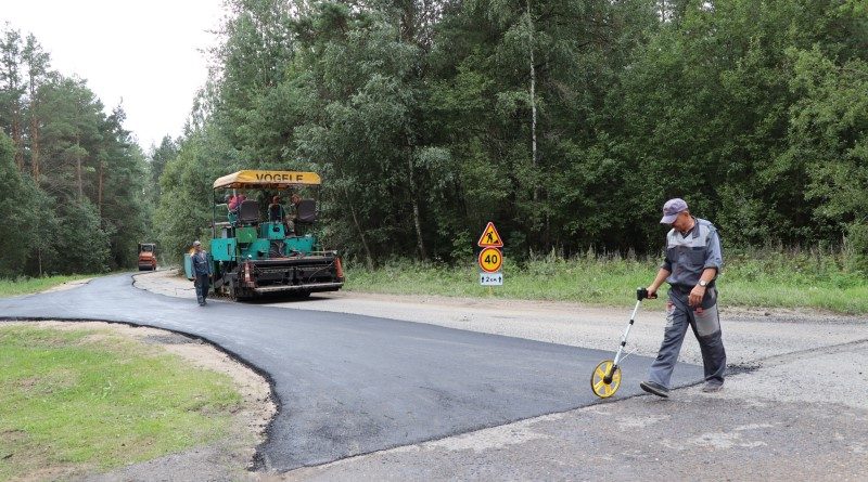 Работнікі ДРБУ № 180 укладваюць асфальт на дарозе Бягомль – Дубавік.